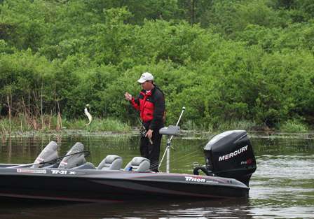Co-angler Rob Moodie slings a bass in the boat just before the skies open up and a deluge of rain sets in over Wheeler Lake. This will be the second day anglers have had to fish in pouring rain.