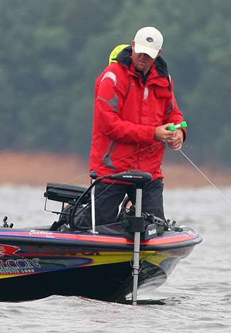 Williamson picks up a marker buoy while keeping a close eye on his rod for a worm bite.