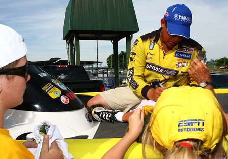 Prior to arriving at the stage, Day Three leader Bobby Lane signs autographs for the young fans.
