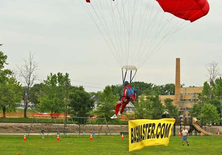 Bassmaster.com receives publicity as a parachutist lands near the weigh-in stage with a banner in tow.