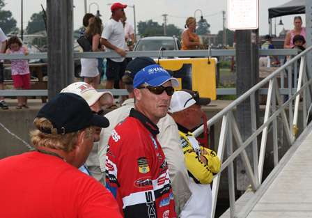The first flight of anglers wait in line to get their transport bags for carrying their fish to the staging area.