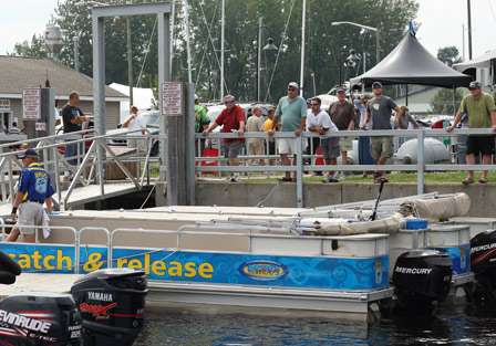 Fans watch as the anglers load fish into bags and make their way to the tanks.