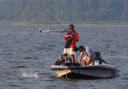 Johnston fights a bass to the boat as his co-angler Bobby Lanham goes for the net.