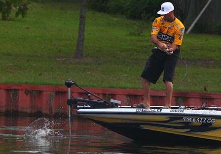 Swindle pulls his best bass of the day along the side of his boat.