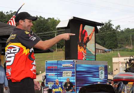Kevin VanDam points into the crowd and then points his live well, as his intro video plays in the background.
