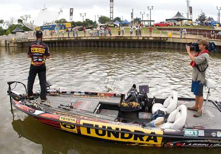 Mike Iaconelli fishes near the weigh-in area Friday as spectators watch the action.