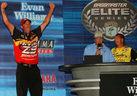 Kevin VanDam celebrates as emcee Keith Alan makes his fifth title official and challenger Skeet Reese looks on.