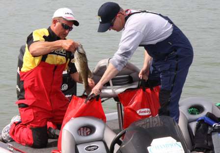 Pro Cliff Blackford gets help from co-angler Stuart Swanger as they load their transport bags to carry their Day One catch to the scales.