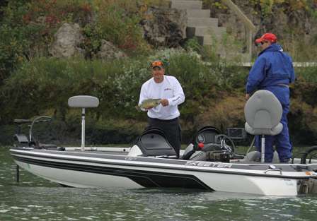 Bill Brown shows his bass to the cameras before placing it in the livewell as his co-angler Mike Chunko looks on.