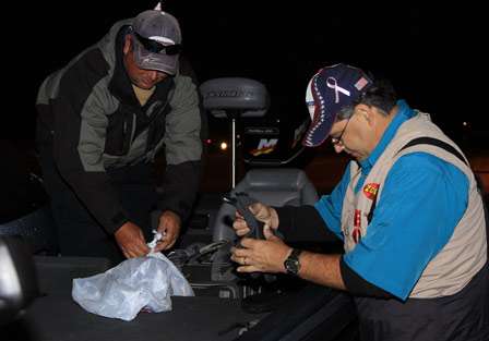 Pro Tommy Murphy helps his co-angler Pat Nettles get settled into his boat prior to launching on Day One.