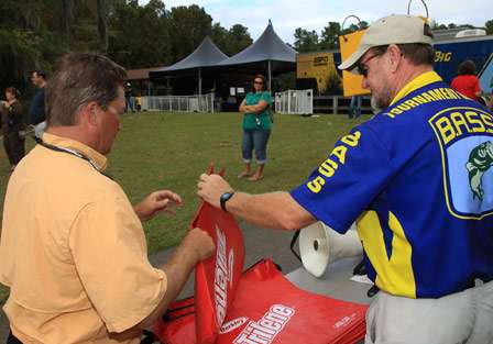 BASS Official, Max Leatherwood, gives Jim Barnette transportation bags at the docks prior to weigh in.