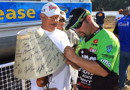 Bassmaster Elite Series pro Fred Roumbanis signs his autograph on a handmade 