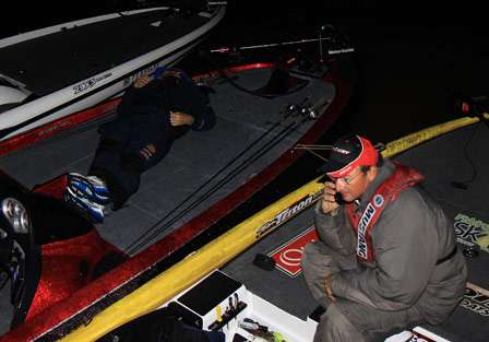 Bassmaster Elite pro Cliff Pace sprawls out on the front deck of his boat as Elite pro Gary Klein makes the same call he makes before each day at every tournament, to his family.