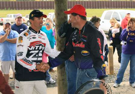 After placing his fish on the scale, Smith congratulates Evers on the win.