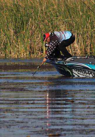 Bassmaster Elite Series pro Chris Lane tries to free his bait after working it deep into matted cover. 