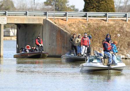 There is a line of fans following local angler Russ Lane under a small bridge on Lay Lake.