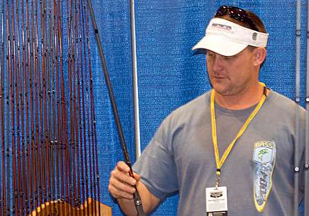 Jeff Sruen from Vian, Okla., looks over a baitcasting rod at the Falcon booth.