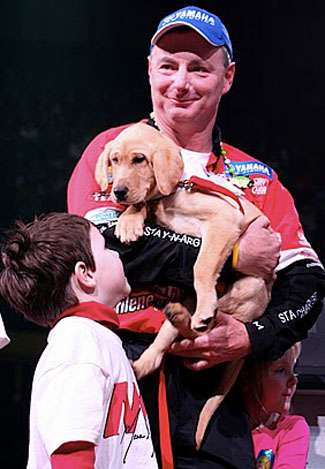 Mark Menendez gets the puppy on stage.
