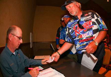 Tommy Biffle presents his California fishing license to Trip Weldon during Wednesday's angler meeting.