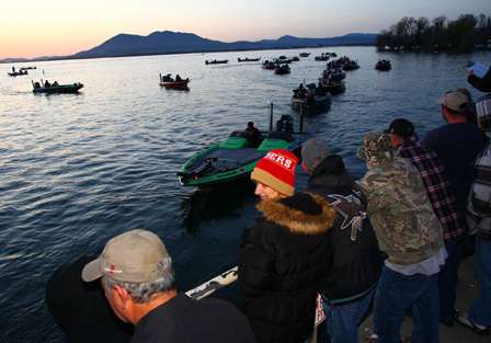 Scott Ashmore and the remaining Elite Series anglers line up and idle through the morning inspection as spectators look on.