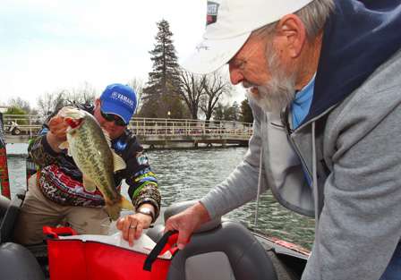 Bill Lowen places one of his hefty Clear Lake bass into a weigh-in bag.
