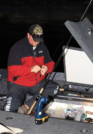 Arkansas pro Jim Dillard sets up a makeshift work area with a portable light as he makes lure changes early on Day One.