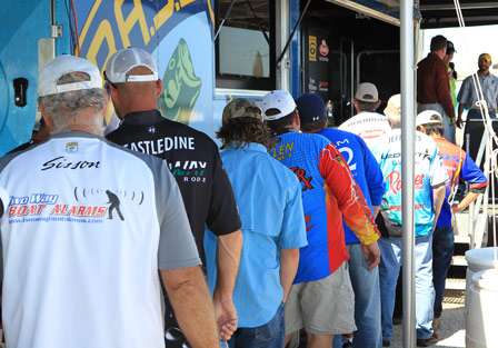 The anglers line up at the tanks to the side of the stage as they wait their chance to get their final official weight.