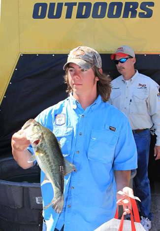 A tournament employee sports a handful of bass, while co-angler Mark Powers poses in the background for a personal photo.