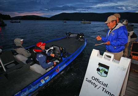 Alton Jones gets ready to take off as BASS officials inspect his boat and livewells.