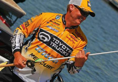 Terry Scroggins wraps the line around his rod before storing it in his rod locker.