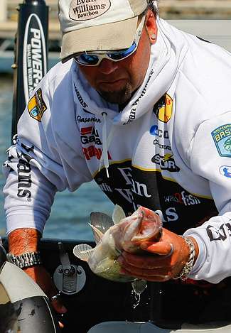 Jason Quinn pulls a bass out of the livewell before heading to the Day One weigh-in of the Alabama Charge.