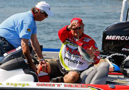 Matt Reed grabs the culling clip to help move his fish from the livewell to the weigh-in bag on Thursday.
