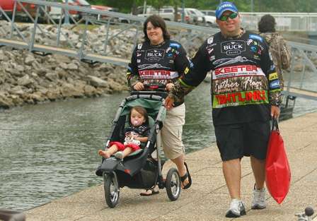 Bill Lowen walks down the dock to the weigh-in accompanied by his wife, daughter and a bag of fish.