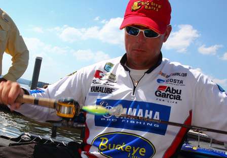 Russ Lane twists the line around his rods before storing them in the rod locker of his boat.