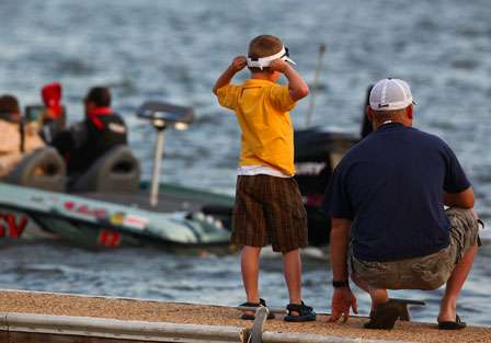 A young fan stretches while watching the 47 Elite Series anglers make their way out onto Lake Guntersville Saturday.
