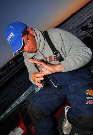 Cliff Pace puts adhesive bandages on the crucial spots of his hands, which were ripped up from handling so many fish this week.  