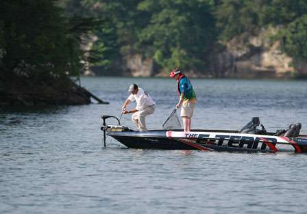 Pro David Walker holds his rod tip low, trying his best to keep the bass from jumping as his co-angler John Moon prepares the net. The next 4 photos show the catch sequence.