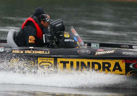 As he makes a move to another fishing location, Iaconelli ducks behind his Lowrance unit to protect himself from the rain. 
