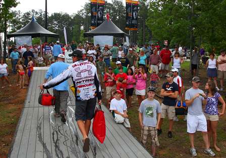 Williamson walks up the dock as a large crowd gathers around to see the anglers check in.