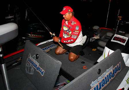 Matt Reed gets takes out his rods and tackle while waiting for the take-off Sunday morning.