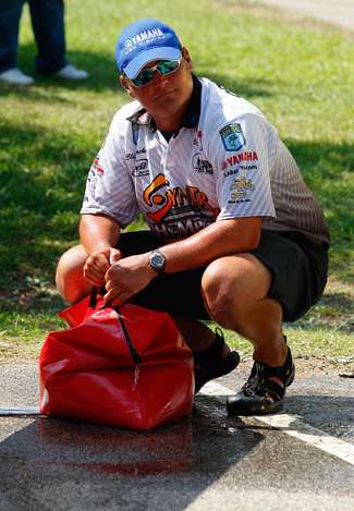 Cliff Crochet crouches with his bag of fish as he waits to be brought up to the stage.