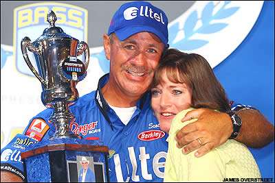 Bassmaster Legends winner Scott Rook is joined on stage and congratulated by wife Kathy.