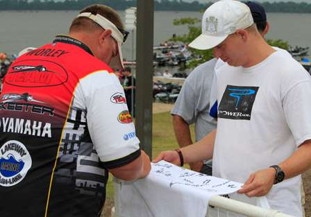 Derek Goudeau (right) stood at the exit of the stage and had every angler sign a Bass Pro Shops T-Shirt as a memento for the Bass Pro Shops Bassmaster Central Open #2.
