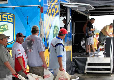 Anglers stand to the side of the stage, ready to finally see what their official weight will be.