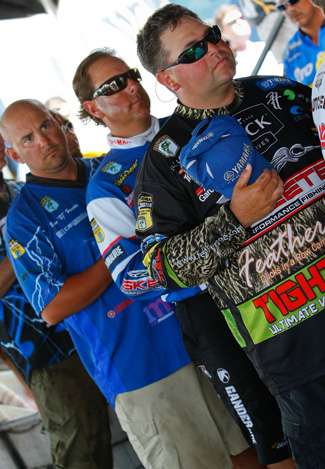 Elite Series anglers remove their hats for the playing of the national anthem prior to the Day Two weigh-in.