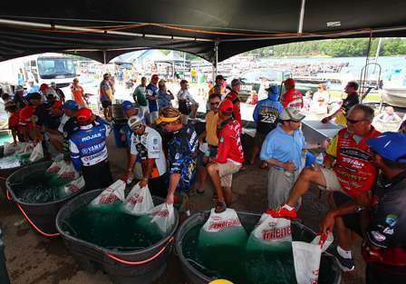A line of Elite Series anglers hold their bags at the tanks prior to weigh-in.