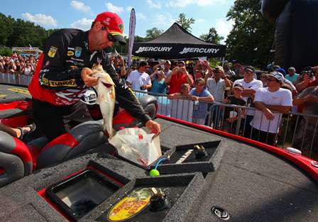 Kevin VanDam places one of his winning fish in a weigh-in bag. 
