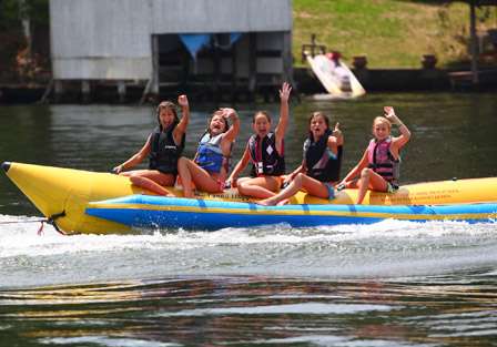 A group of girls on a banana raft tell Aaron Martens that they like his boat.