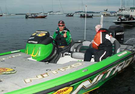 Timmy Horton gives a thumbs-up as his co-angler closes up the live well.  