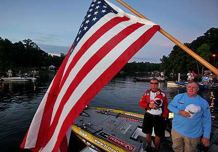 Anglers and spectators show respect as the Day Two national anthem is played.